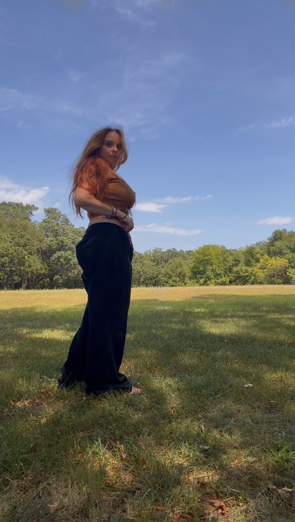 Liz standing outdoors in a grassy field